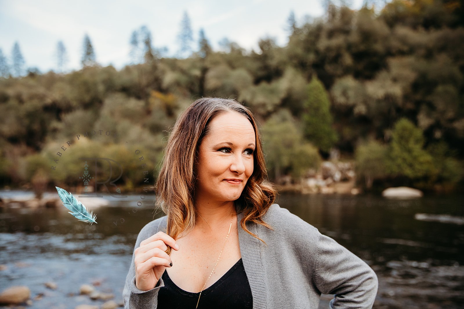Founder by a river with forested hillside behind her